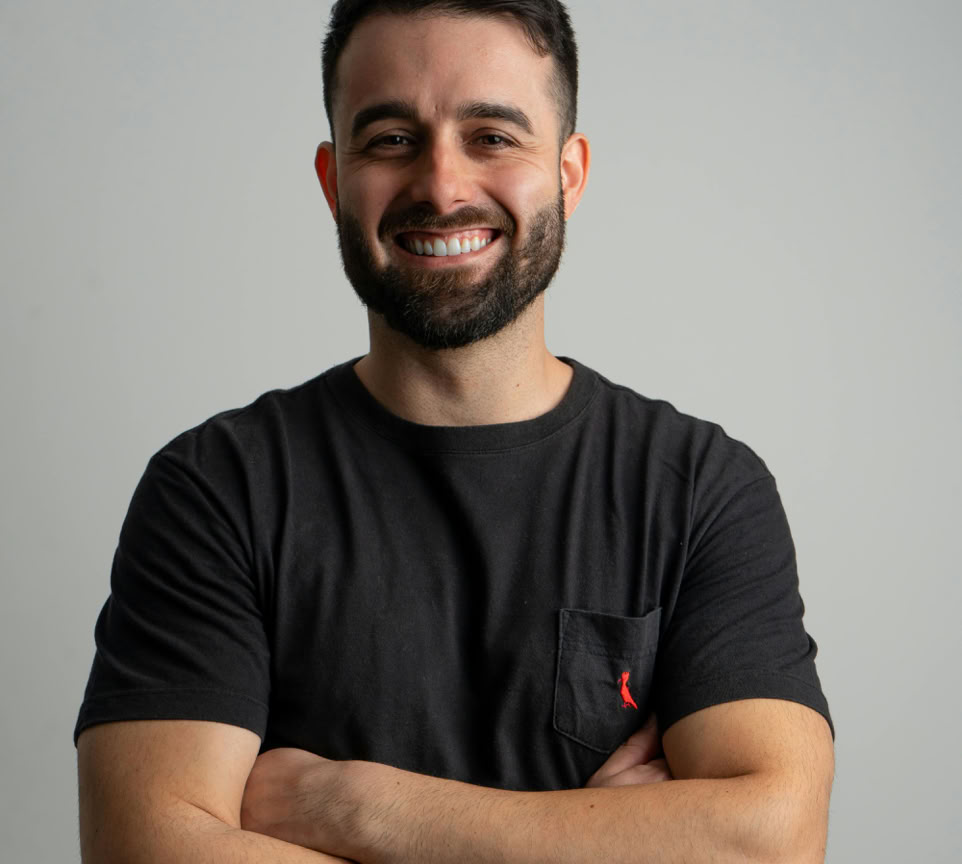 Smiling man in a casual black shirt posing for a professional portrait.