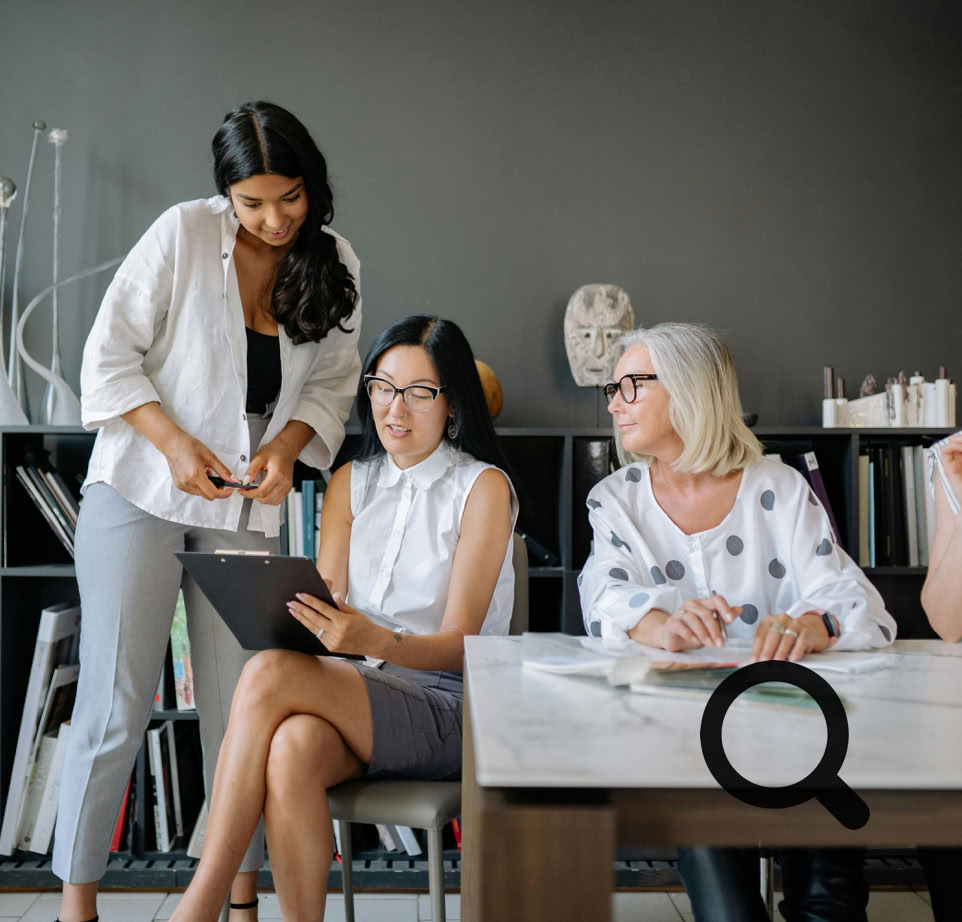 Four women collaborating in a contemporary office setting, focusing on teamwork and diversity.