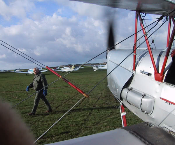Four professionals engage in a friendly discussion in a modern office corridor.