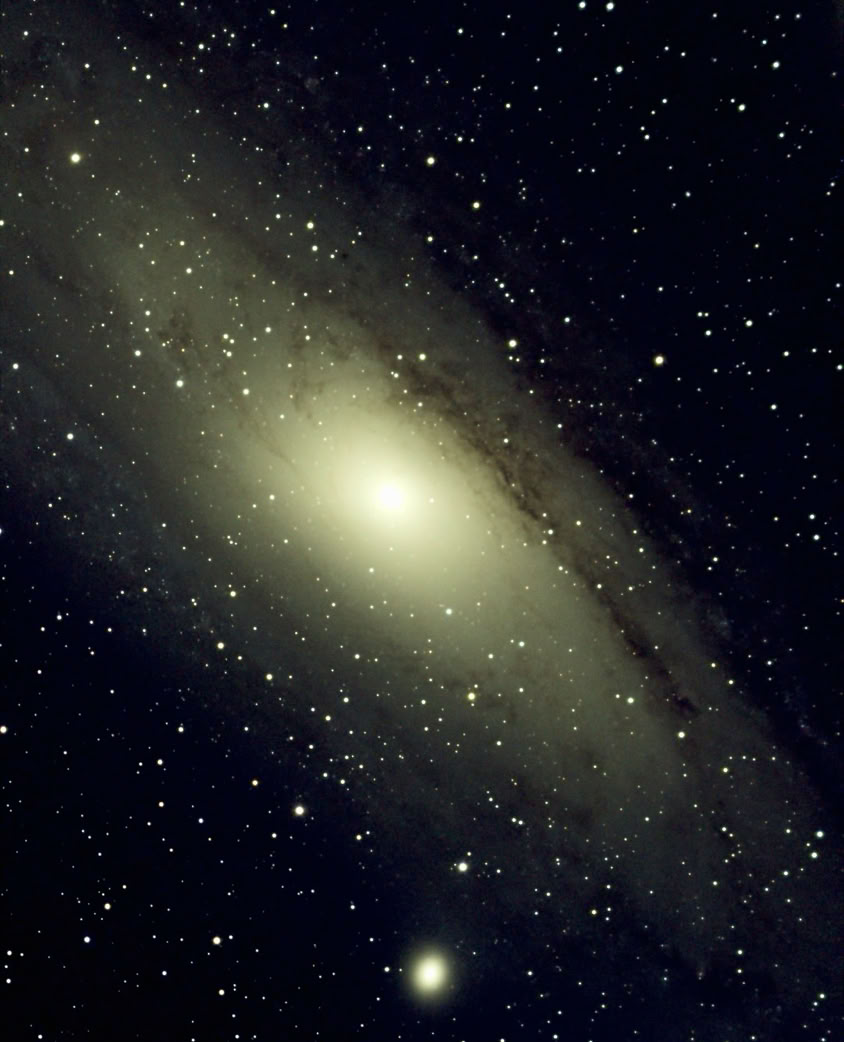 Whiskey glass with ice, vintage photos, and jewelry on a piano creates a nostalgic scene.
