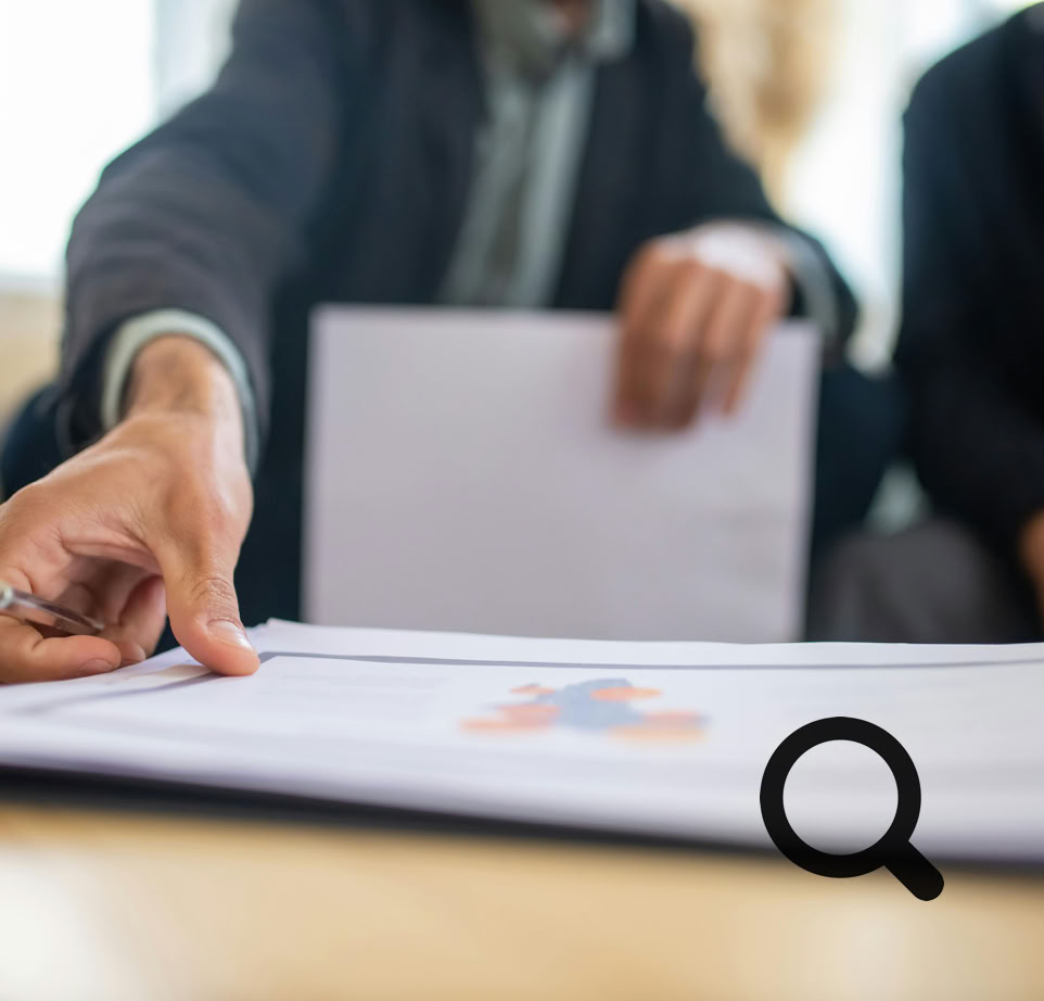 Close-up of a businessman reviewing important documents at a desk in an office setting.